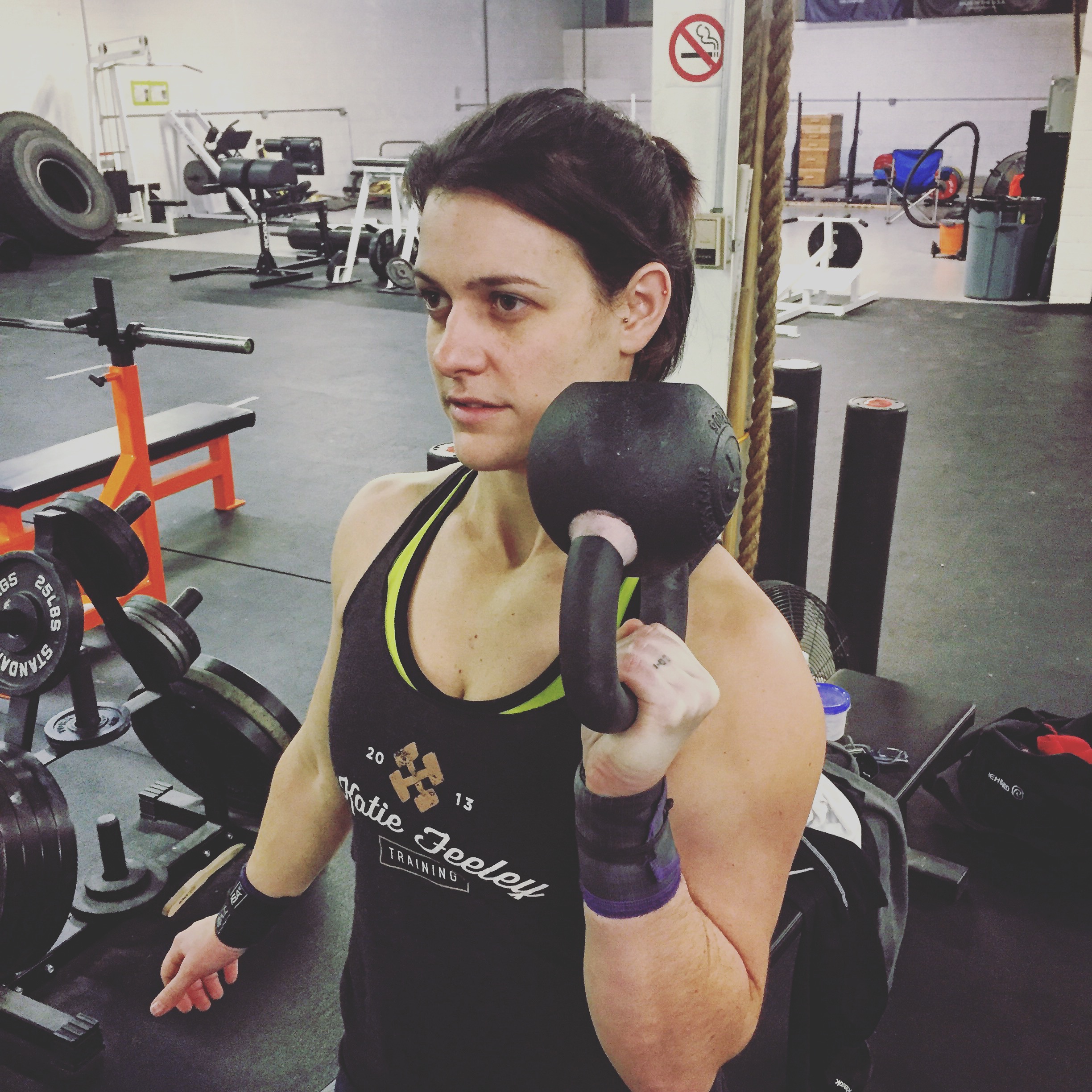 woman performing single arm kettlebell press