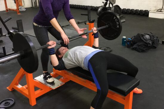 Shera spotting Katie on a bench press