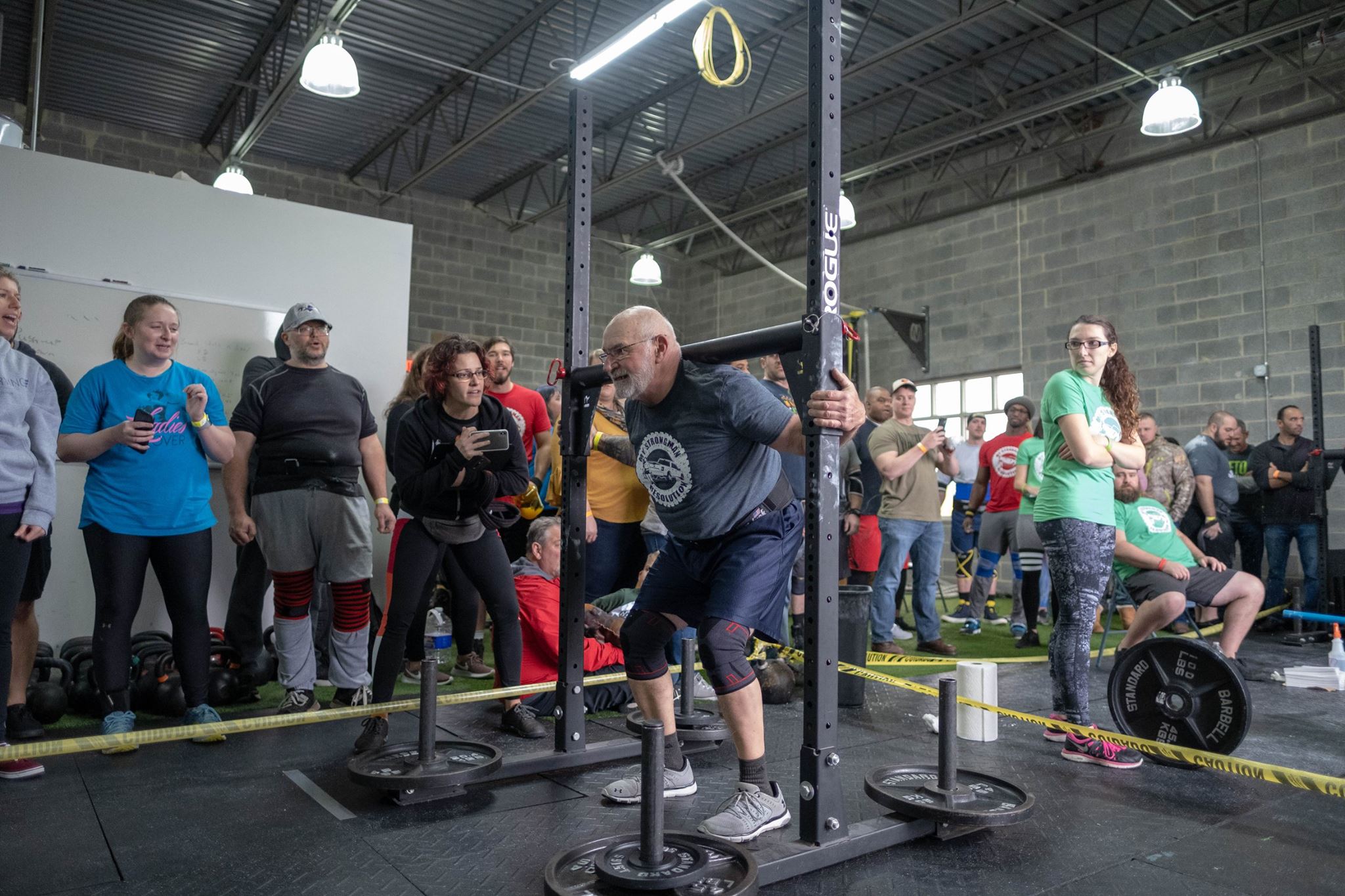 Katie coaching Glenn on yoke carry at a strongman competition