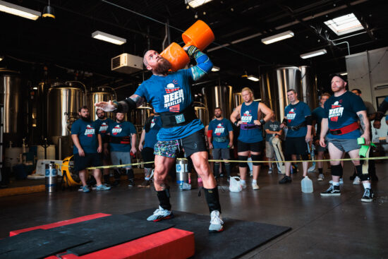 male athlete preparing to press a circus dumbbell at a strongman competition